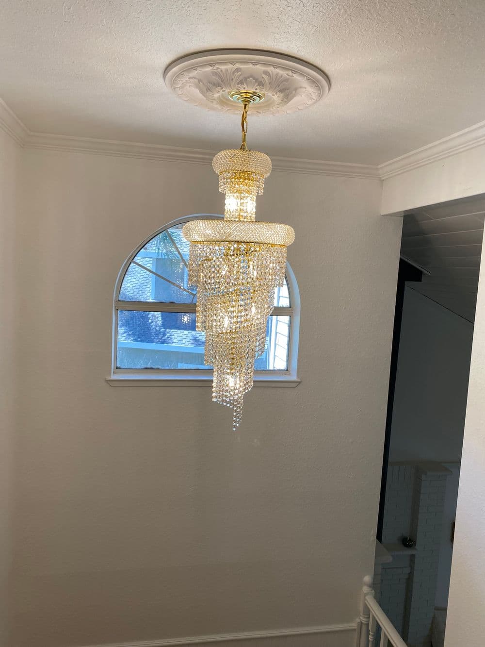 Elegant chandelier with crystal beads hanging from a decorative ceiling medallion.