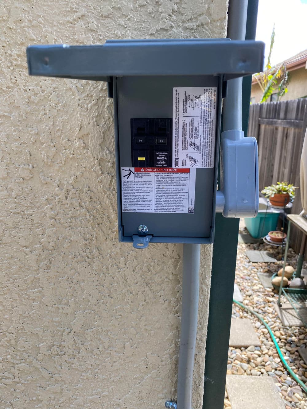 Electrical disconnect box mounted on a wall with instructions and warning label.