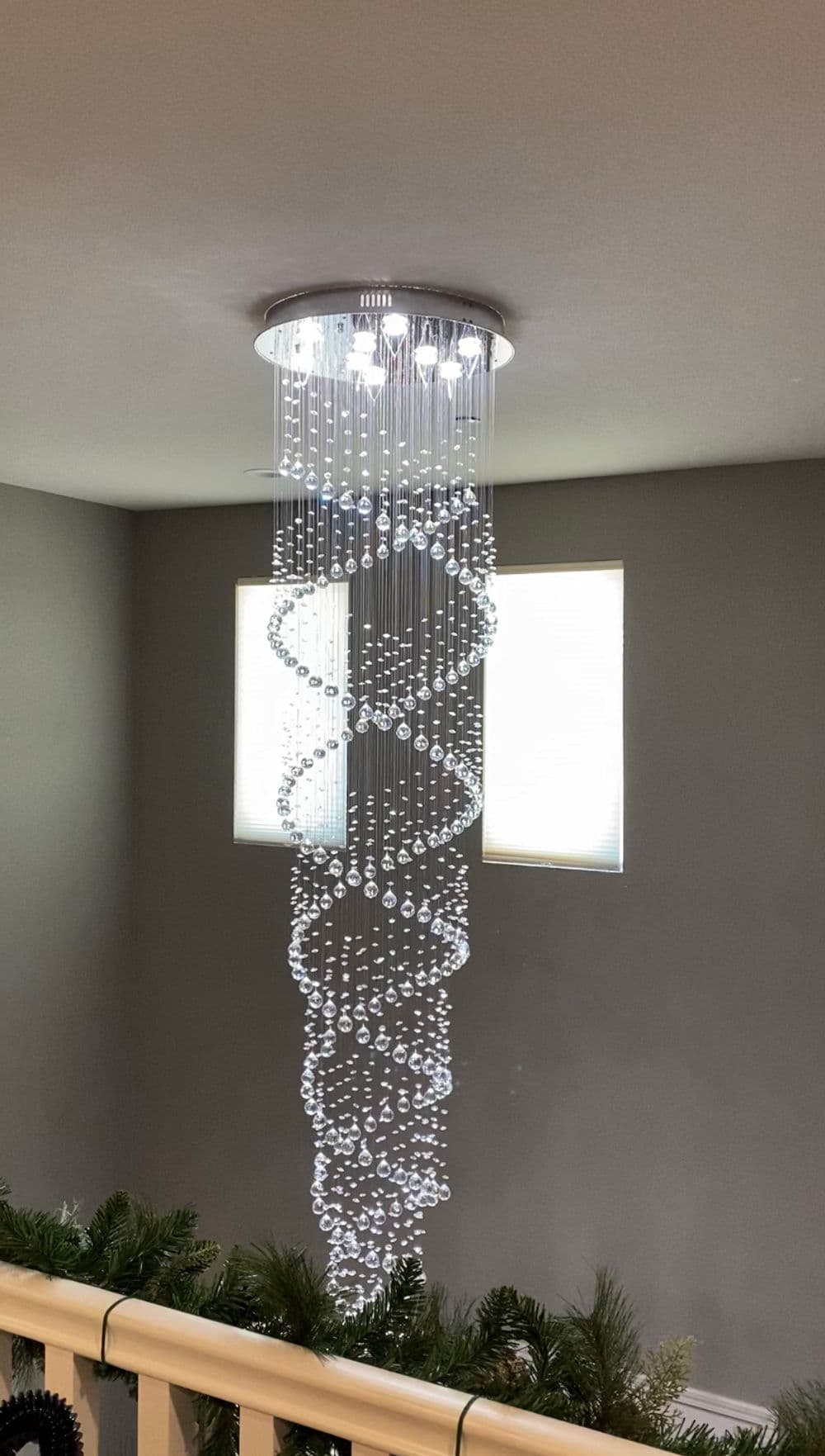 Modern chandelier with a spiral design, featuring crystal accents and bright lighting.