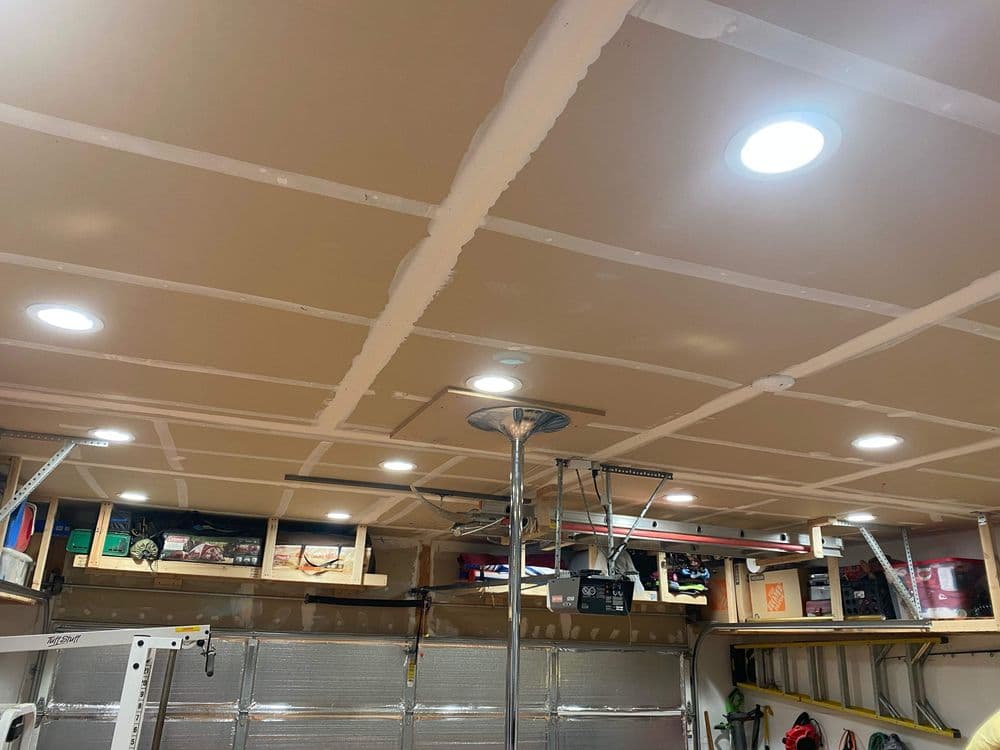 Brightly lit garage interior with recessed lighting and organized storage shelves.