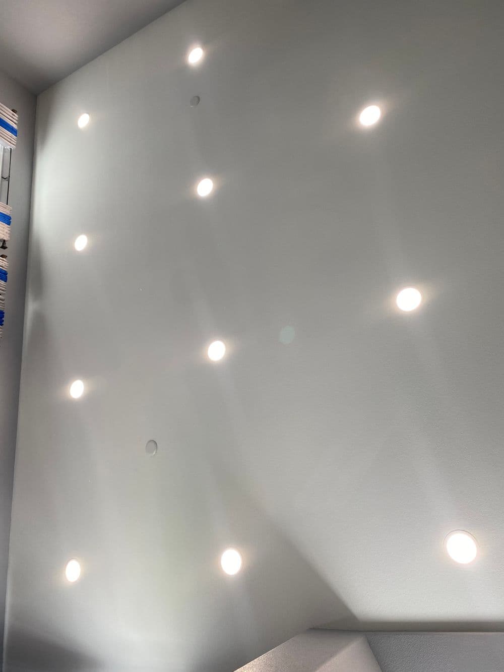 Ceiling with multiple recessed lights illuminating a modern space.